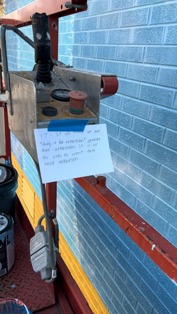 An index card from the cards program taped to the scissor lift